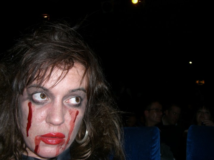 Foreground: hideous corpse. Background: serious cinemagoers